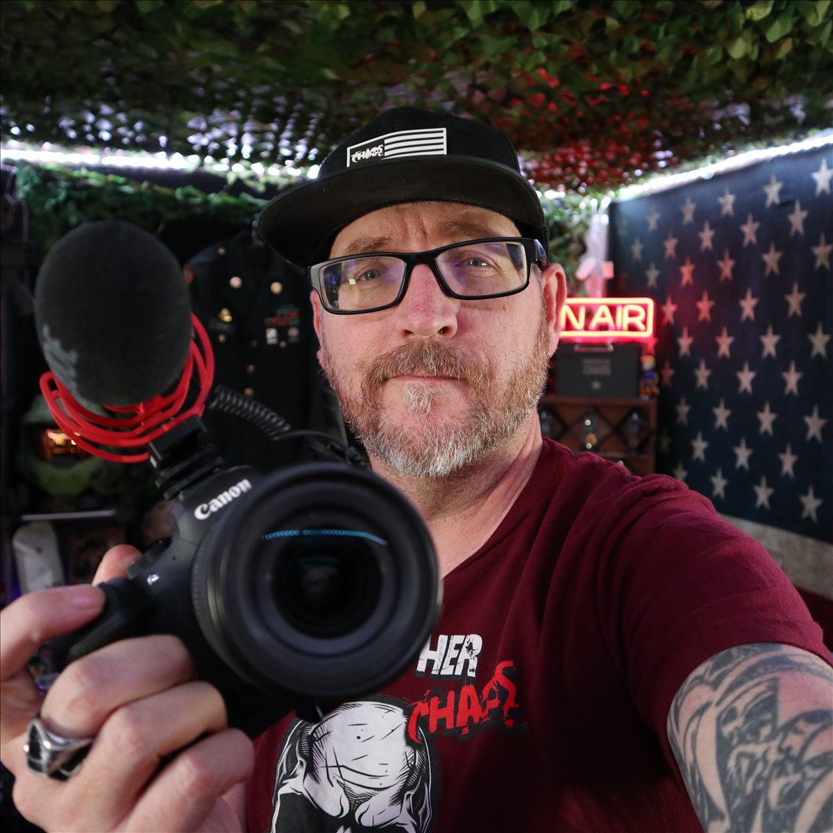 Christopher Chaos holding a camera in his studio